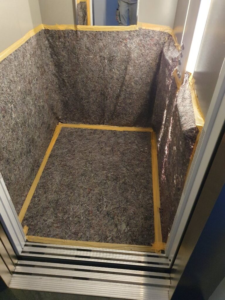 Abgedeckte Laufwege und geschützter Aufzug während einer Wasserschadensanierung